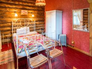 a bedroom with a metal bed with two chairs at Park Hotel Berendeevka in Kostroma