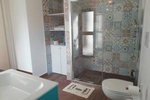 a bathroom with a shower and a toilet and a sink at Kasakarma in Agira