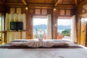 a bed with a white swan in the middle at Phi Phi The Beach Resort in Phi Phi Islands