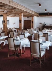 une salle à manger avec des tables et des chaises blanches dans l'établissement Ferienwohnung Grischuna, à Bivio