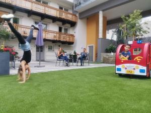 Ein junges Mädchen, das einen Handstand im Gras macht. in der Unterkunft Kinderhotel Stefan in Wenns