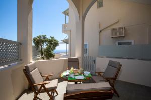 a patio with a table and chairs on a balcony at Erato Apartments in Firostefani