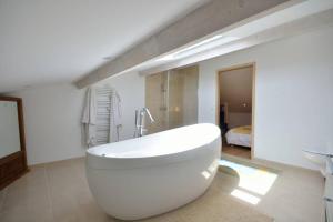 a white bathroom with a tub and a bedroom at Villa lours in Le Trayas +16 photos