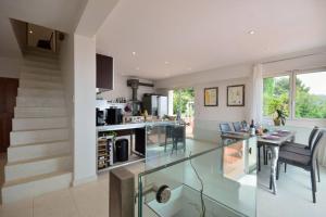 a living room with a glass table and a kitchen at Villa lours in Le Trayas