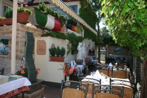 an outdoor restaurant with tables and chairs and plants at Hotel Restaurant Da Franco in Rastatt