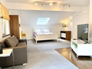 a living room with a couch and a television at Auszeit im Chiemgau, Ferienwohnungen in Rottau