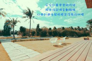 two chairs and a table on a wooden deck at Shark B&B in Hengchun