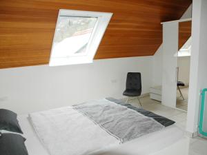 Schlafzimmer mit einem Bett, einem Fenster und einem Stuhl in der Unterkunft Ferienwohnung Sylvianne in Ottenhöfen