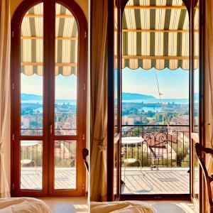 a bedroom with large windows with a view of the city at Cá Leon in La Spezia