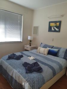 a bedroom with a blue bed with bows on it at Park Beach Cabins in Coffs Harbour