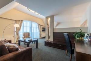 een woonkamer met een bank en een tafel bij Vital&Spa Resort Szarotka in Duszniki Zdrój