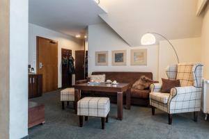 uma sala de estar com um sofá e uma mesa em Vital&Spa Resort Szarotka em Duszniki Zdrój