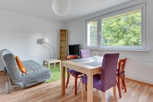 ein Wohnzimmer mit einem Tisch und Stühlen in der Unterkunft Wave Apartments - Tysiąclecia in Danzig