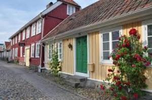 una fila de casas rojas y amarillas en una calle en Hotell Vesterhavet en Falkenberg