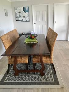 a dining room table with two chairs and a wooden table at Pine View Holiday Rental in Emu Bay