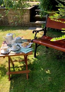 a picnic table with a tea set on it next to a bench at Ellen House Bed and Breakfast in Matlock