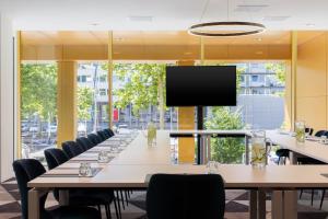 a large conference room with tables and chairs and a flat screen tv at Holiday Inn Express Amsterdam - North Riverside by IHG in Amsterdam