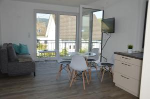 eine Küche und ein Wohnzimmer mit einem Tisch und Stühlen in der Unterkunft Wein & Gästehaus Porten-Becker in Köwerich