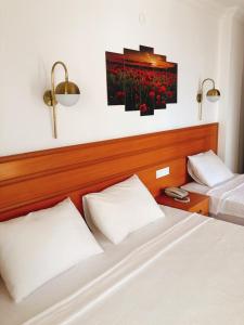 a bedroom with two beds and a painting of flowers at Kekova Hotel in Kaş