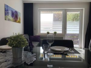 a living room with a glass table with wine glasses at Apartment Anna-Eva in Winterberg