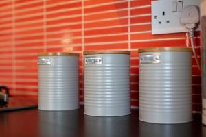 tres pilas de latas de plata sentadas en un mostrador en Walker Suite No82 - Donnini Apartments en Kilmarnock