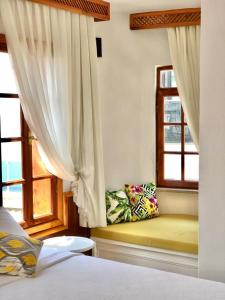 a bedroom with a bed and two windows at Kekova Hotel in Kaş