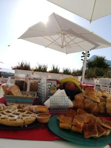 - une table garnie de différents types de pain et de viennoiseries dans l'établissement Map Enjoy Rooms, à San Vito Lo Capo