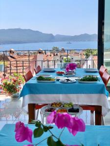 a table with plates of food and flowers on a balcony at Kekova Hotel in Kaş