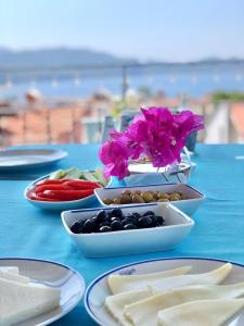 Kekova Hotel في كاس: طاولة زرقاء مع أطباق من الطعام والزهور عليه