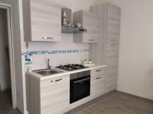a small kitchen with a sink and a stove at Casa di Giò - Alghero in Alghero