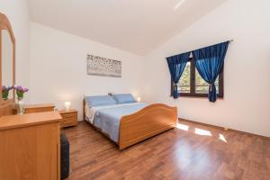a bedroom with a bed with blue sheets and a window at Apartment Astoria in Zaton