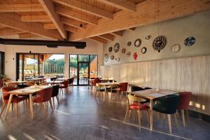 un ristorante con tavoli e sedie in legno e finestre di Mobile Homes Camping Plitvice a Smoljanac