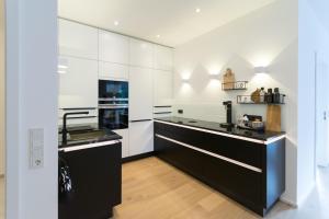eine Küche mit weißen Wänden und schwarzen Arbeitsplatten in der Unterkunft LOFT17 Neu Luxus-Loft Design Klima 2-4 Personen in Traben-Trarbach