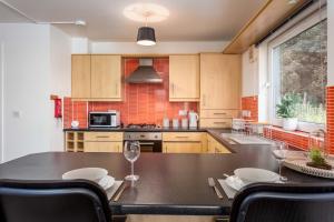 Walker Suite No82 - Donnini Apartments في كيلمارنوك: مطبخ مع طاولة مع كؤوس للنبيذ عليه