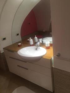 un baño con lavabo y espejo en TraMura Camera con vasca idromassaggio, en Trapani