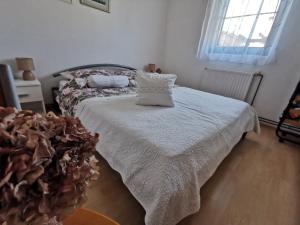 a bedroom with a bed with white sheets and a window at Apartmani Antonela&Andrej in Privlaka