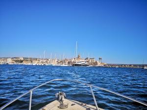 a boat in the water with a city in the background at Casa di Giò - Alghero in Alghero