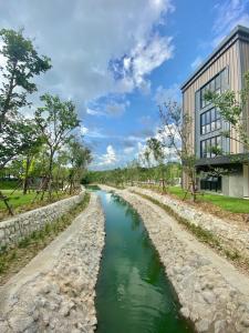 a river in front of a building at GREENHILLS RESORT Si Racha in Ban Nong Wa