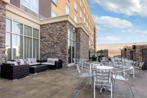 eine Terrasse mit Tischen und Stühlen und ein Gebäude in der Unterkunft Holiday Inn Southaven Central - Memphis, an IHG Hotel in Southaven