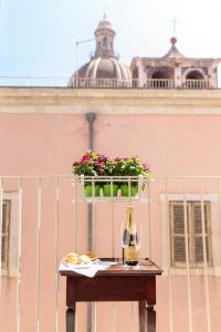 un tavolo con una bottiglia di vino e un bicchiere di B&B LA CUPOLA a Catania