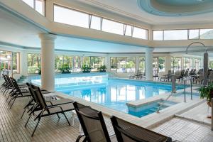 a large swimming pool in a building with chairs at Hotel Apollo Terme in Montegrotto Terme