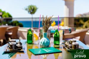 a table with green bottles and plates of food at Hotel Prova in Ulcinj