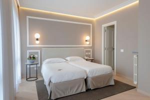 um quarto com uma grande cama branca e 2 almofadas em Hotel Apollo Terme em Montegrotto Terme