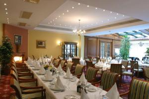 uma sala de jantar com mesas e cadeiras brancas em Hotel AS em Zagreb