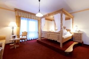 1 dormitorio con cama con dosel y espejo en Landhotel Post en Heiligenblut