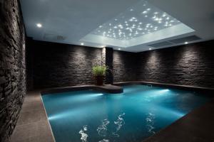 a swimming pool in a room with a ceiling with lights at Trosa Stadshotell & Spa in Trosa