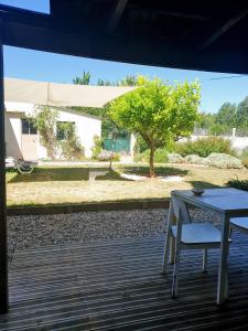 a table and chair on a deck with a tree at Estudio Tanner in Pedrógão Grande