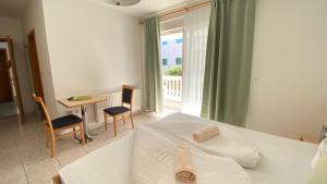 a bedroom with a bed and a table and a window at Villa Osipovica in Medulin