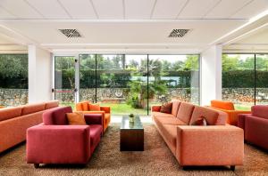 a living room with orange furniture and large windows at Hotel Mediteran Plava Laguna in Poreč