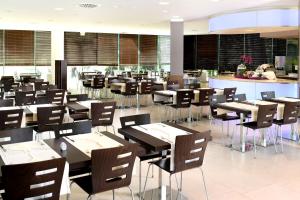 a dining room with tables and chairs in a restaurant at Hotel Mediteran Plava Laguna in Poreč